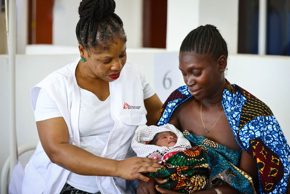 Doctors Without Borders/Médecins Sans Frontières (MSF) midwife with a mother and child in the maternity ward.